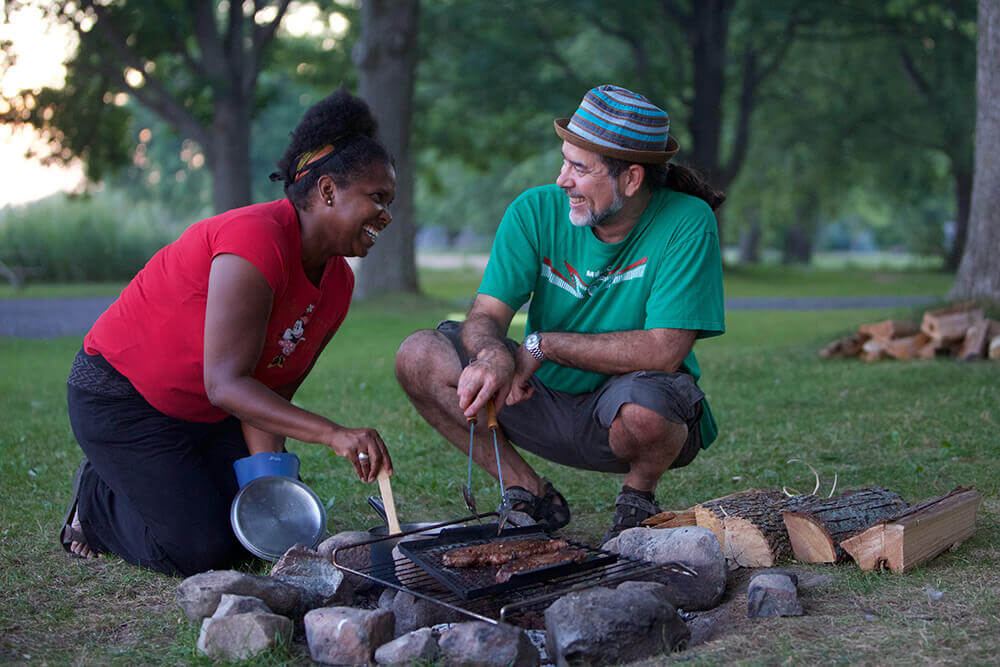 Man and woman around a campfire