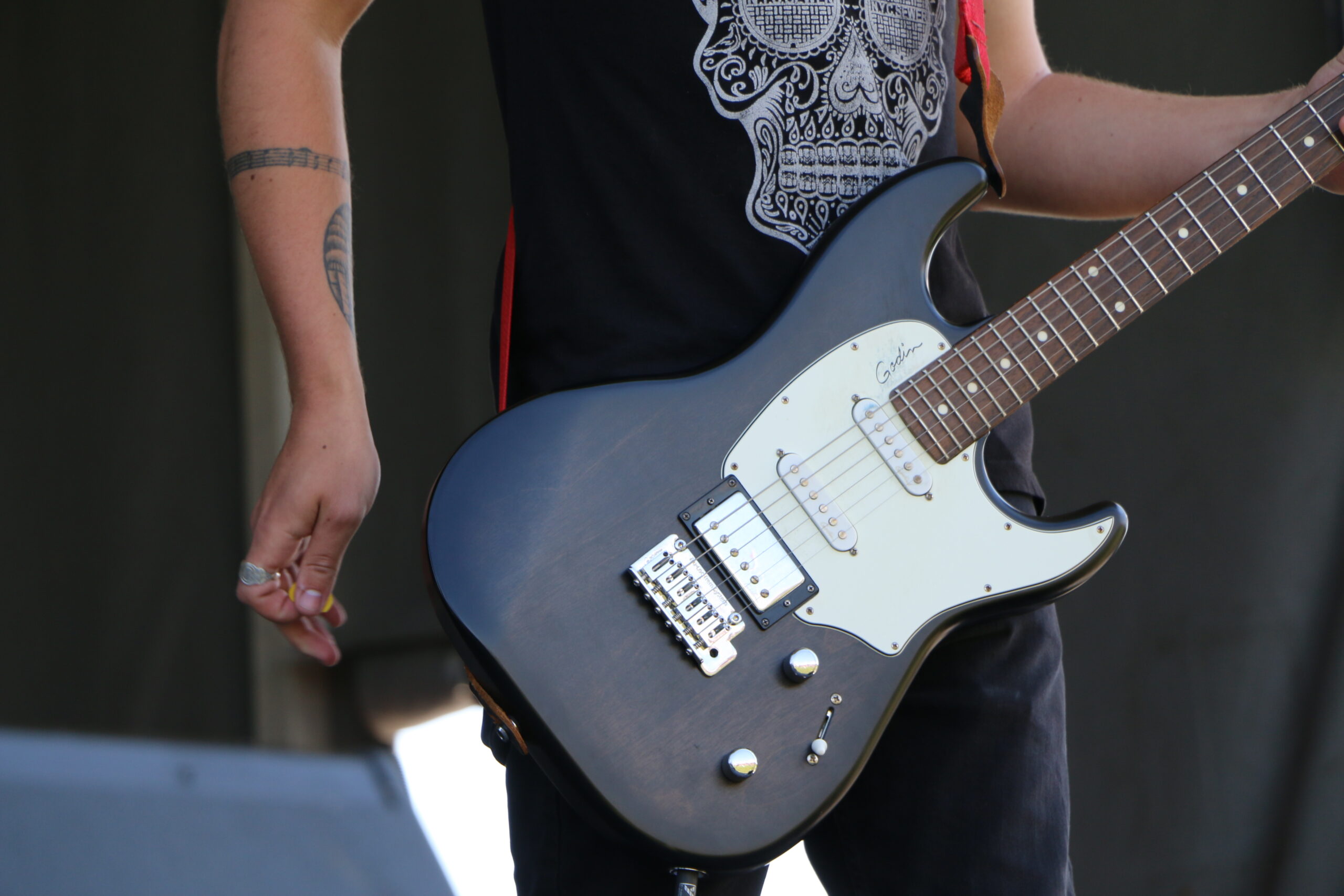 Black guitar being played by musician.